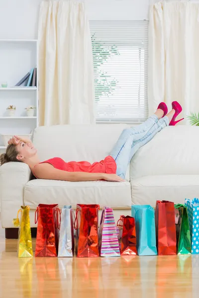 Mulher relaxante no sofá depois de fazer compras — Fotografia de Stock