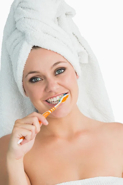 Smiling woman with hair towel washing her teeth — Stock Photo, Image