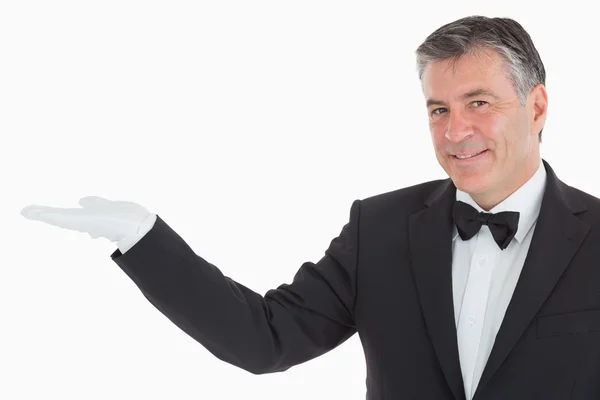 Smiling waiter showing us his opened hand — Stock Photo, Image