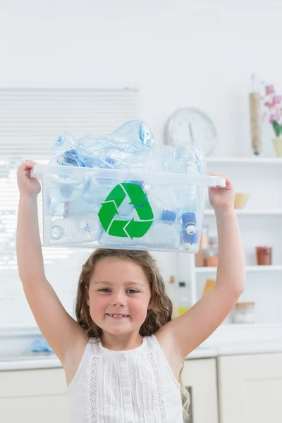 Girl holding crate with plastics on her head — Stock Photo, Image