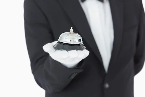 Well-dressed man holding a hotel bell — Stock Photo, Image