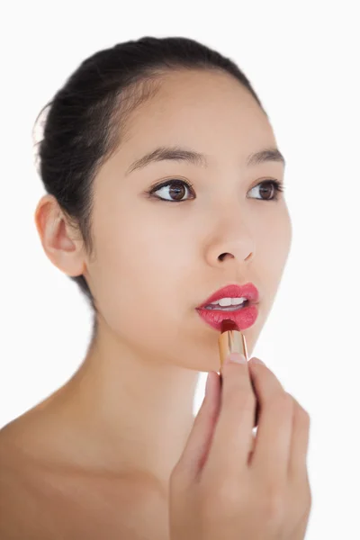 Woman putting on pink lipstick — Stock Photo, Image