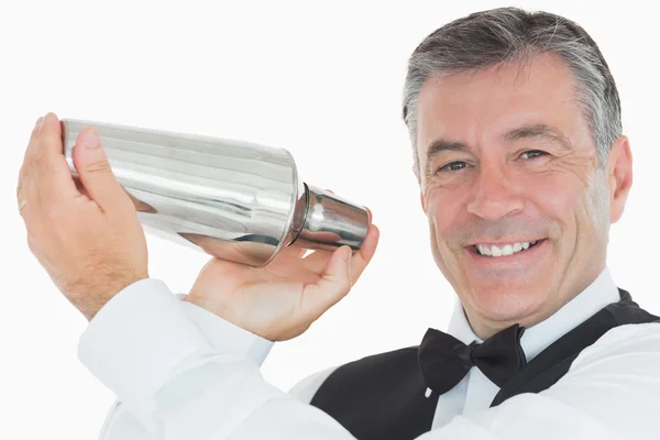 Feliz camarero sacudiendo bebida en coctelera — Foto de Stock