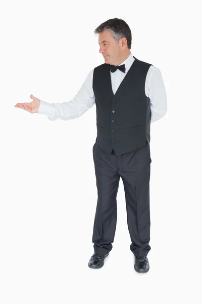 Waiter presenting something to the left — Stock Photo, Image