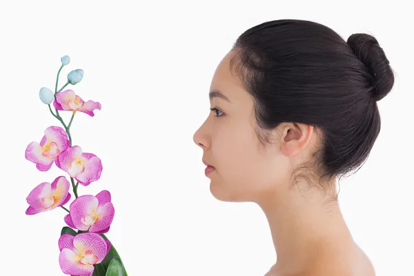 Žena při pohledu na orchideje — Stock fotografie