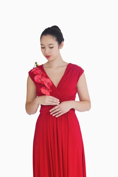 Mulher de vestido de noite vermelho segurando orquídeas — Fotografia de Stock