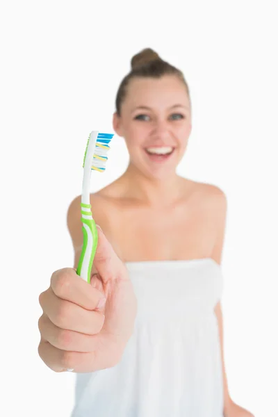 Happy woman showing a toothbrush — Stock Photo, Image