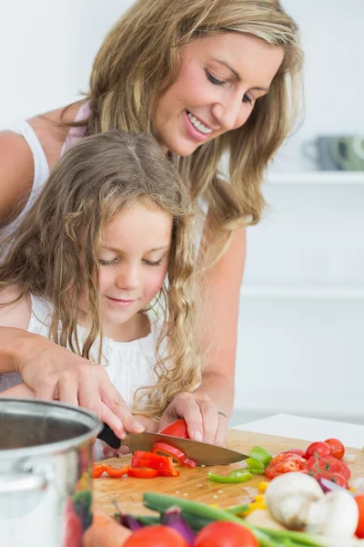 Daughter learning how to cut vegetables — Stock Photo, Image