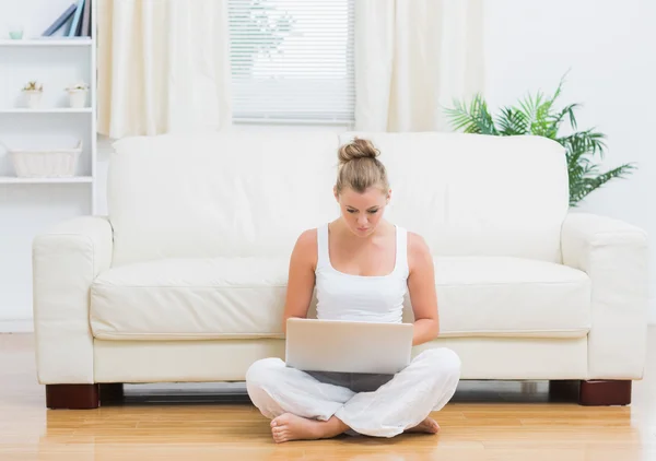 Blondin sitter på golvet med laptop — Stockfoto