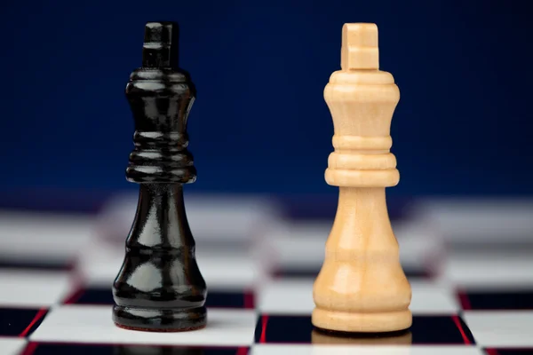 Chess pieces standing at the chessboard beside — Stock Photo, Image