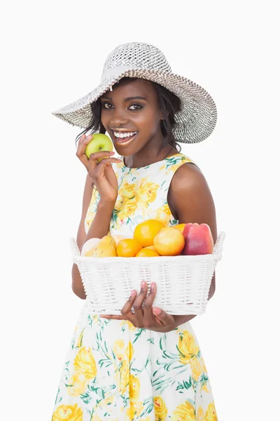 Woman holding a fruit basket and an apple — Stock Photo, Image