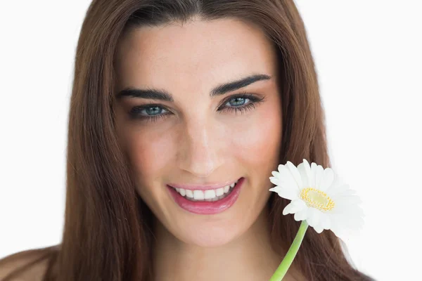 Morena sosteniendo una flor y sonriendo — Foto de Stock