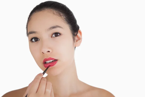 Woman putting on lipstick — Stock Photo, Image