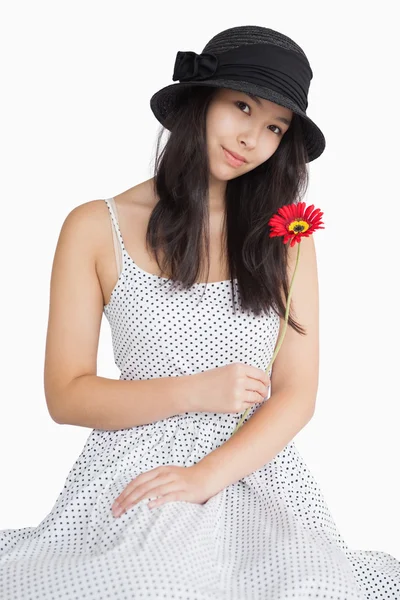 Mulher segurando flor em um vestido de bolinhas — Fotografia de Stock