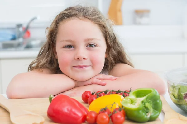 Mädchen lehnt neben Gemüse — Stockfoto