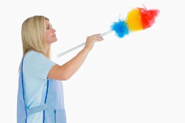 Mujer de limpieza usando un plumero —  Fotos de Stock