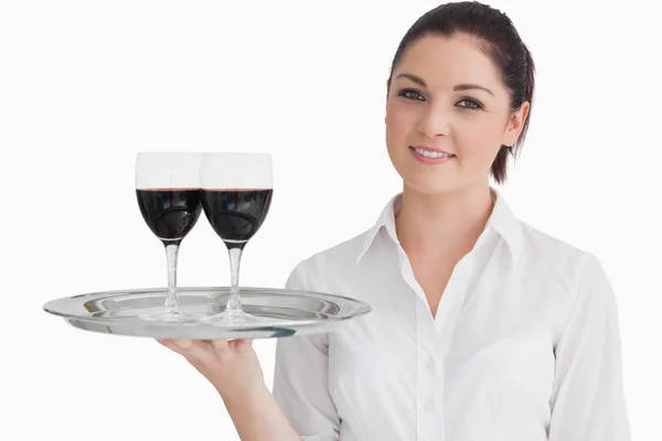 Woman holding tray with glasses of red wine Royalty Free Stock Images