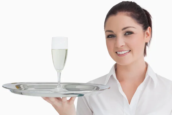 Woman carrying tray with glass of champagne Stock Photo