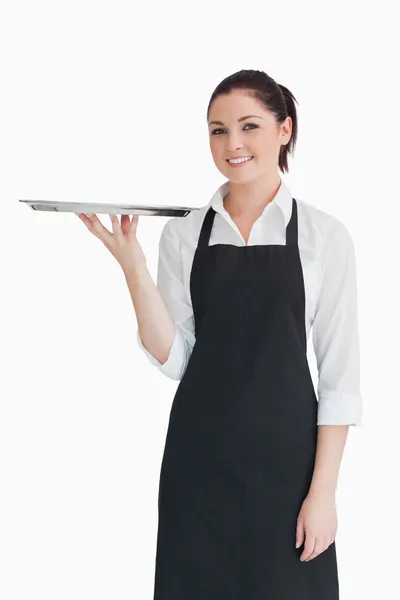 Smiling woman holding an empty silver tray — Stock Photo, Image