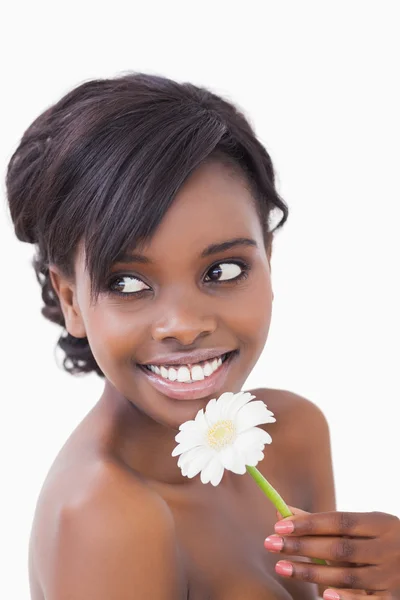 Kvinnan tittar bort när du ler och håller en blomma — Stockfoto