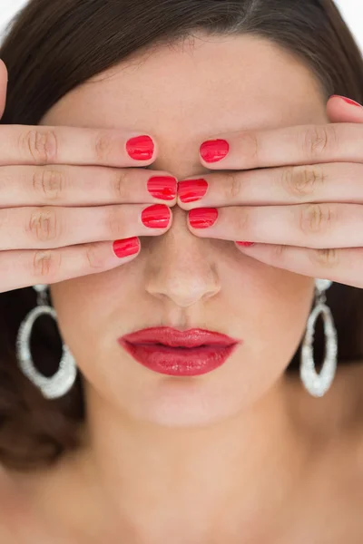 Mulher escondendo seus olhos enquanto vestindo vermelho — Fotografia de Stock