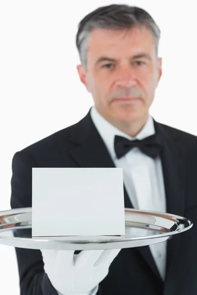 Man holding silver tray with white card — Stock Photo, Image