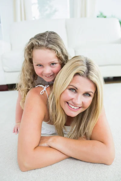 Mother and daughter resting on the carpet — Stock Photo, Image