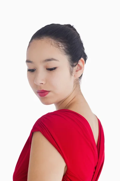 Vrouw in rode jurk glimlachend zachtjes — Stockfoto