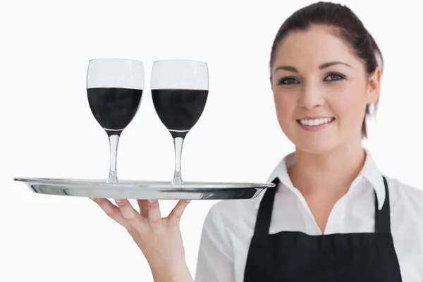 Cheerful waitress holding two glasses of wine — Stock Photo, Image