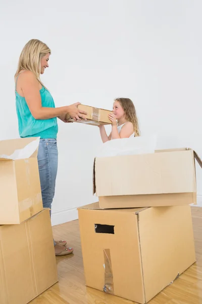 Smiling mother and daughter holding moving box — Stock Photo, Image