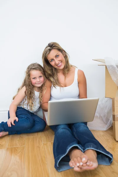 Mãe e filha usando laptop sentado no chão — Fotografia de Stock