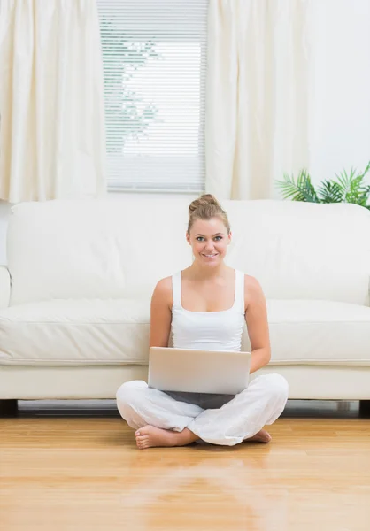 Glada kvinna sitter på golvet med laptop — Stockfoto