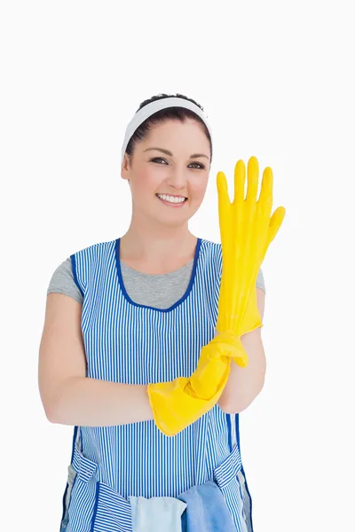 Meid zetten gele handschoenen — Stockfoto