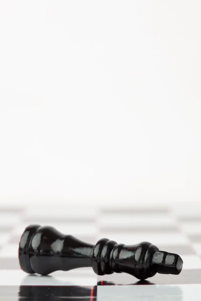 Fekete-Sakkfigura fekszel a sakktábla — Stock Fotó