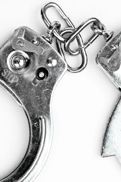 Handcuffs lying against white background — Stock Photo, Image