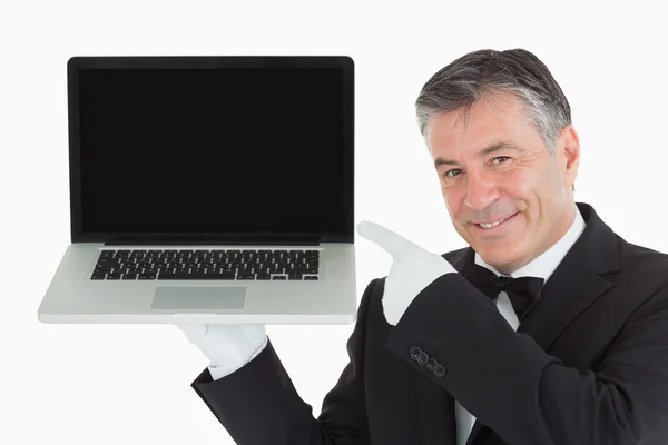 Χαμογελώντας σερβιτόρος μας δείχνει κάτι σε ένα φορητό υπολογιστή — Φωτογραφία Αρχείου