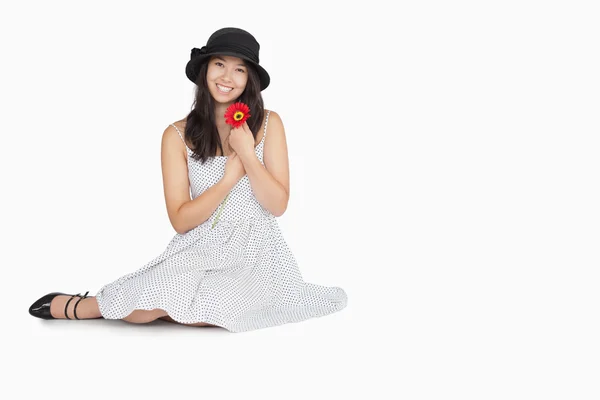 Woman with flower in dress sitting on floor — Stock Photo, Image