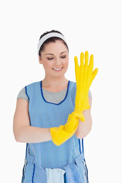 Cleaner woman putting on yellow gloves — Stock Photo, Image