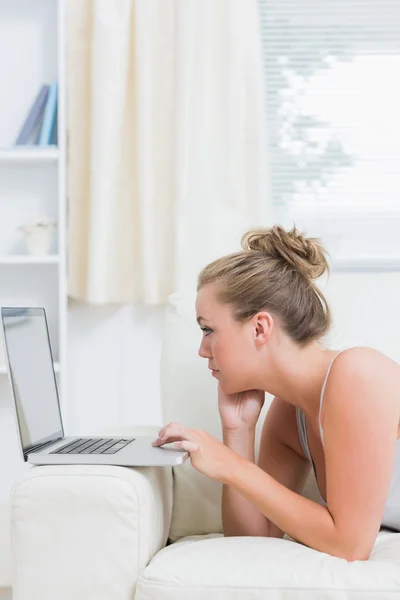 Blondine benutzt Laptop im Wohnzimmer — Stockfoto