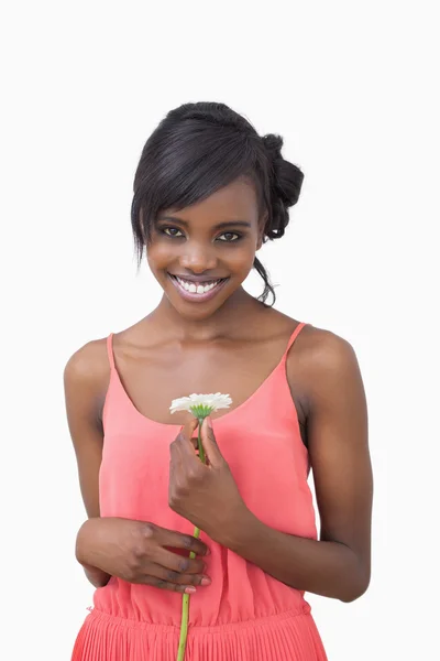 Mujer de pie sosteniendo una flor blanca en un vestido rosa — Foto de Stock