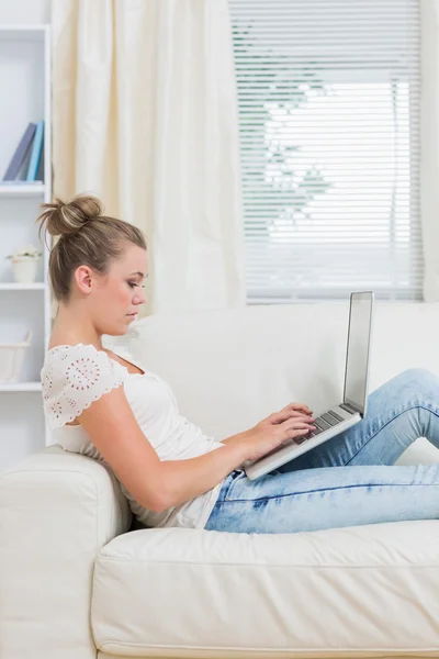 Frau arbeitet am Laptop auf der Couch — Stockfoto