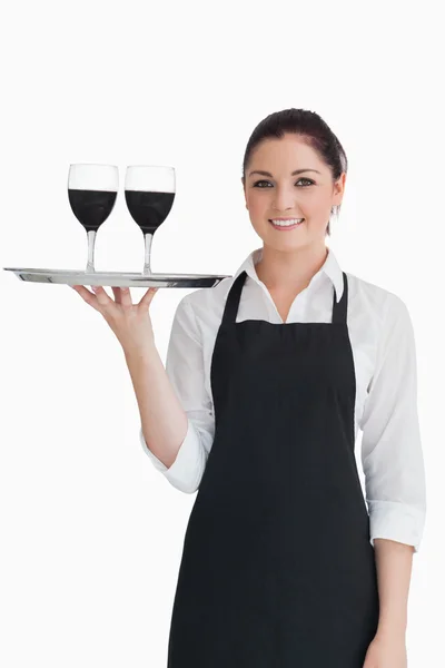 Гарненька офіціантка тримає два келихи вина — стокове фото