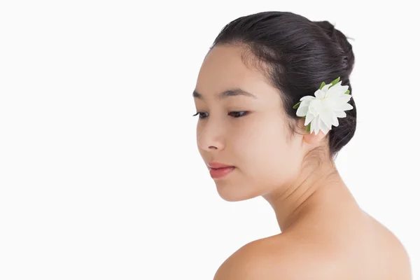 Frau trägt Blume im Haar und schaut weg — Stockfoto