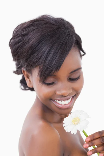 Woman smiling at a flower — Stock Photo, Image