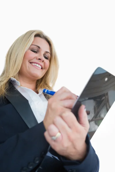 Glückliche Geschäftsfrau schreibt in die Zwischenablage — Stockfoto