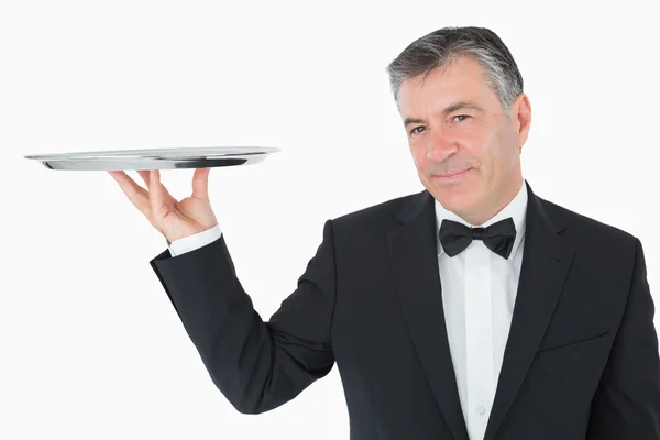 Добре одягнений офіціант тримає срібний піднос — стокове фото
