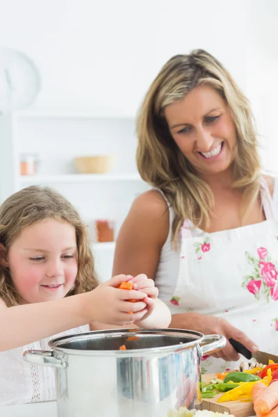 Lachen moeder en dochter voorbereiding van groenten — Stockfoto