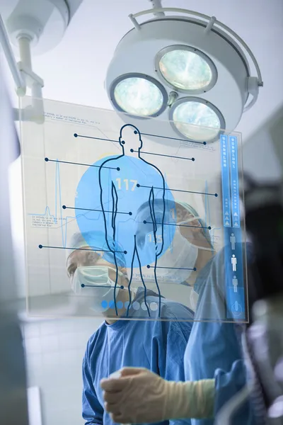 Два хирурга, работающие с медицинским интерфейсом — стоковое фото