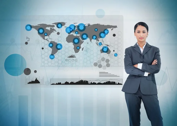 Mujer de negocios seria de pie con un mapa digital del mundo — Foto de Stock