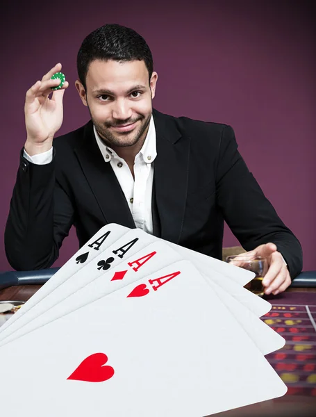 Handsome gambler betting on four aces — Stock Photo, Image